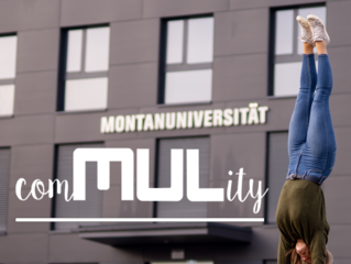 Junge Frau macht einen Handstand vor dem schwarzen Gebäude der Montanuniversität Leoben.