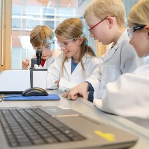 Children in lab coats doing experiments.