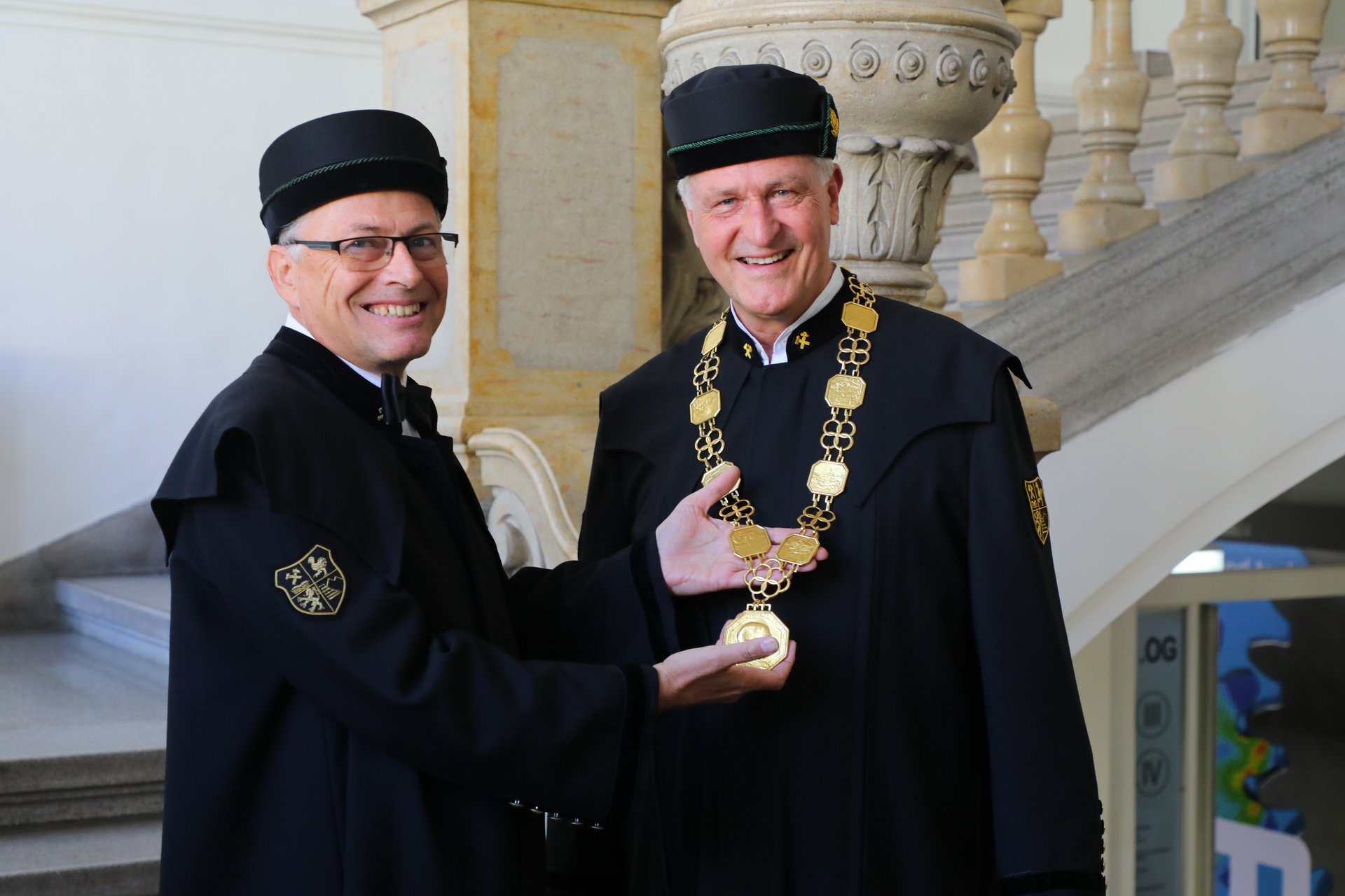 Der bisherige Rektor Wilfried Eichlseder (links) übergab das Amt samt Rektorskette an seinen Nachfolger Peter Moser. [Fotocredit: Foto Freisinger]