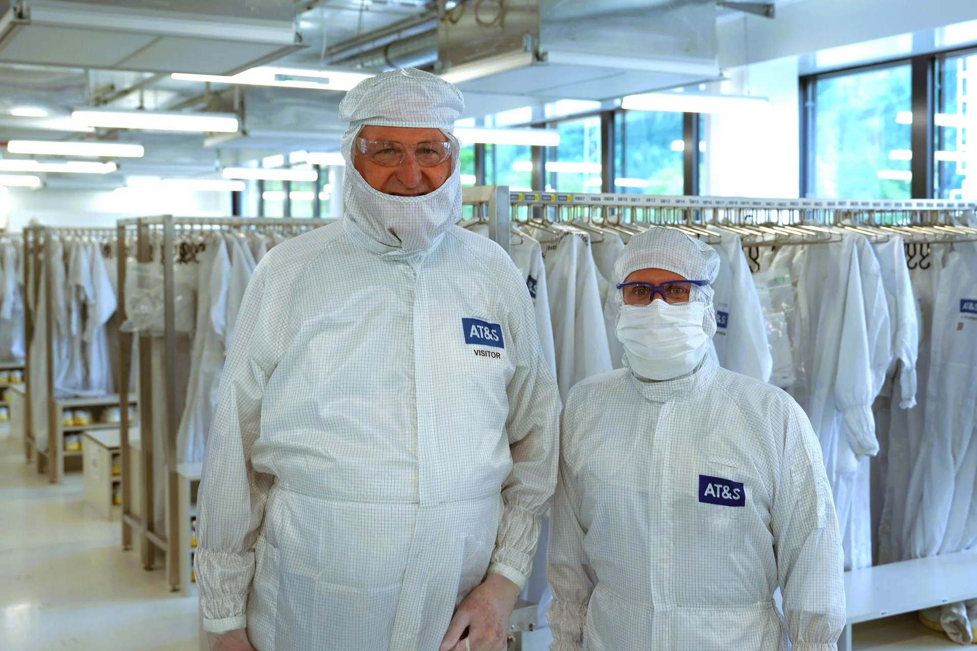 Rector Peter Moser (left) with AT&S substrate expert Martin Münzer, both wearing cleanroom clothing. Photo: © AT&S/Christoph Heigl