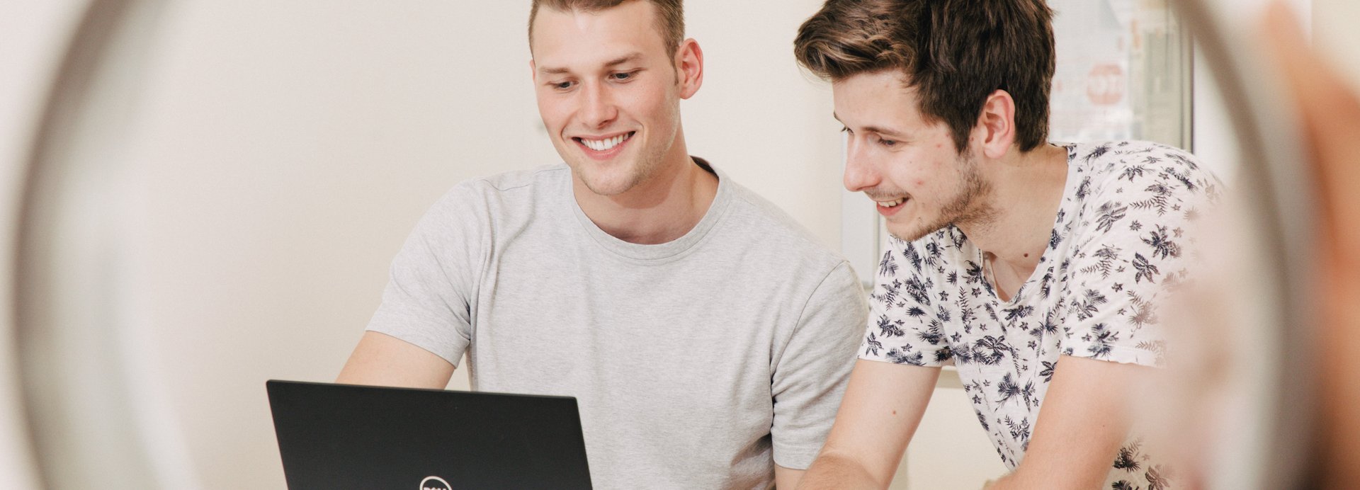 Students sitting in front of their laptops and smiling