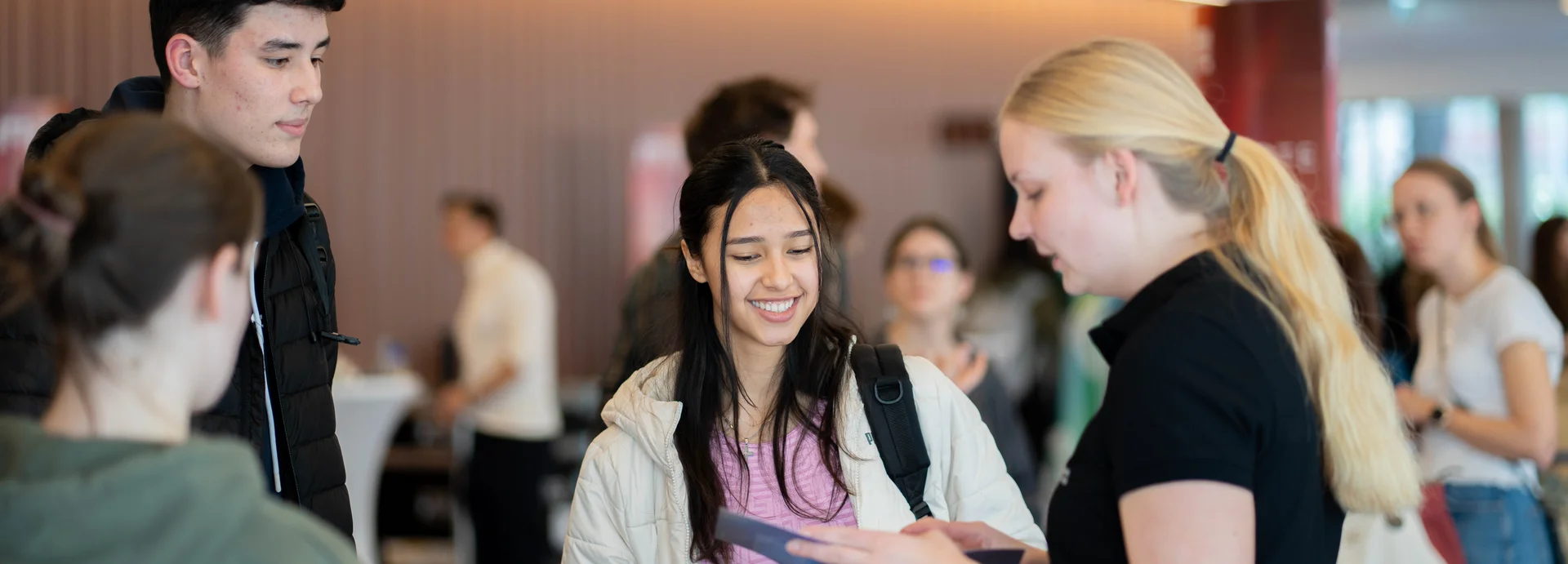 Eine Schülerin und ein Schüler werden von einer Studentin der Montanuniversität Leoben beraten.