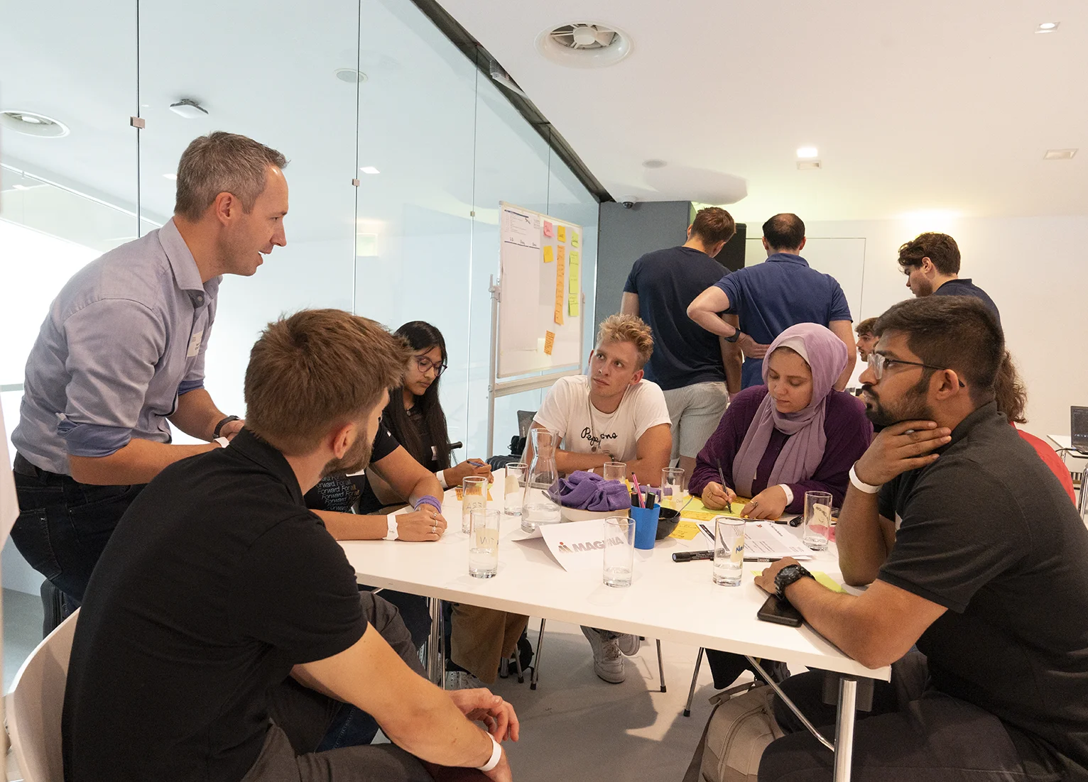 Gruppe von Menschen, die in einem Büro eine Besprechung abhalten anlässlich des Innovationsmarathons der TU Austria.