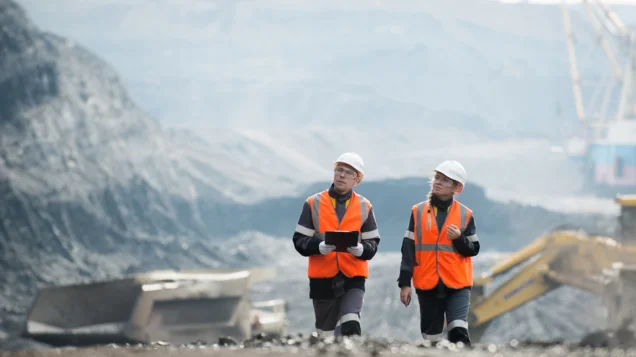 Berg- und Tunnelbau im Kompetenzbereich Rohstoffe an der Montanuniversität Leoben. Foto: © MUL Zwei Personen mit Warnwesten und Helmen stehen umgeben von Bergen und Felsen im Freien.
