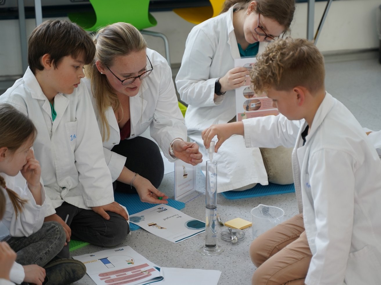 Studenten forschen und experimentieren mit Kindern.