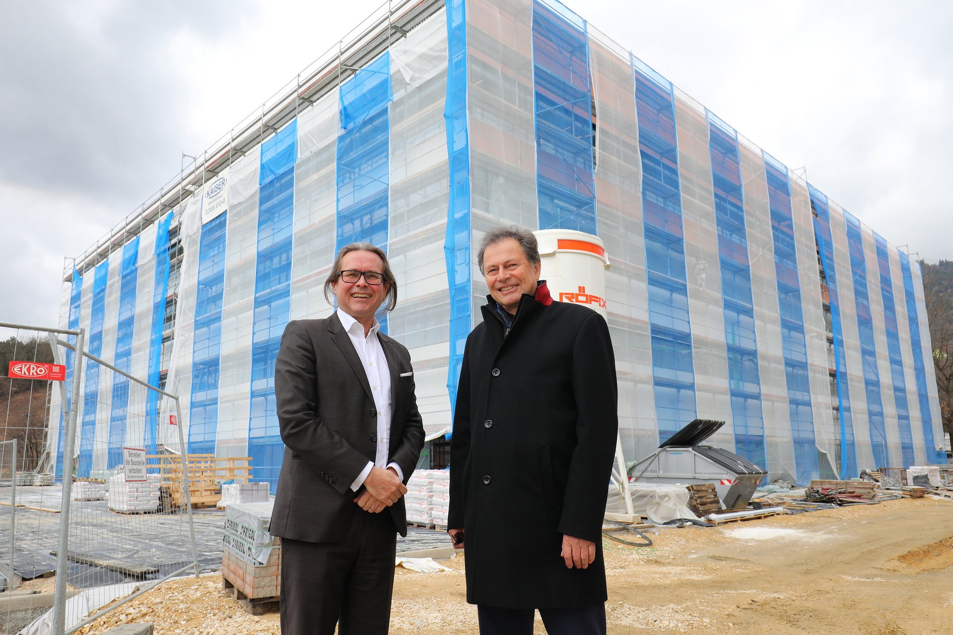 Federal Minister Martin Polaschek together with Rector Wilfried Eichlseder in front of the new study center under construction.