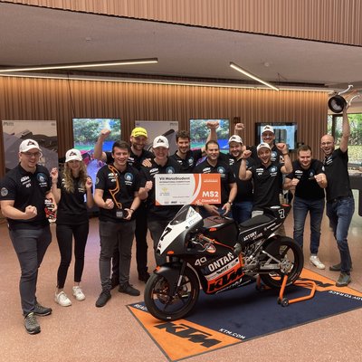 Gruppenfoto vom Racing-Team mit dem Rennmotorrad im Foyer des Studierendenzentrums an der Montanuniversität Leoben.