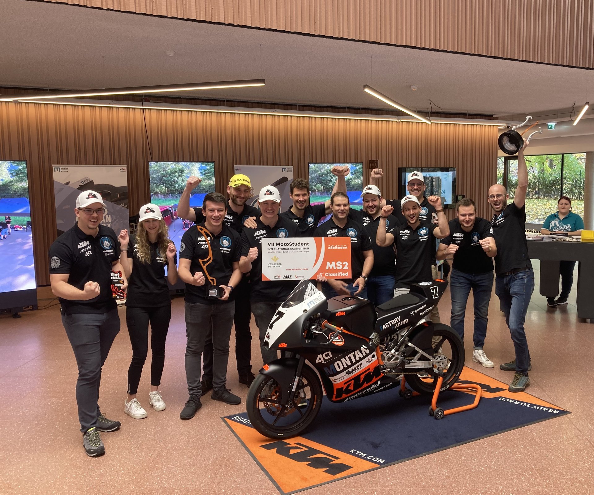 Gruppenfoto vom Racing-Team mit dem Rennmotorrad im Foyer des Studierendenzentrums an der Montanuniversität Leoben.