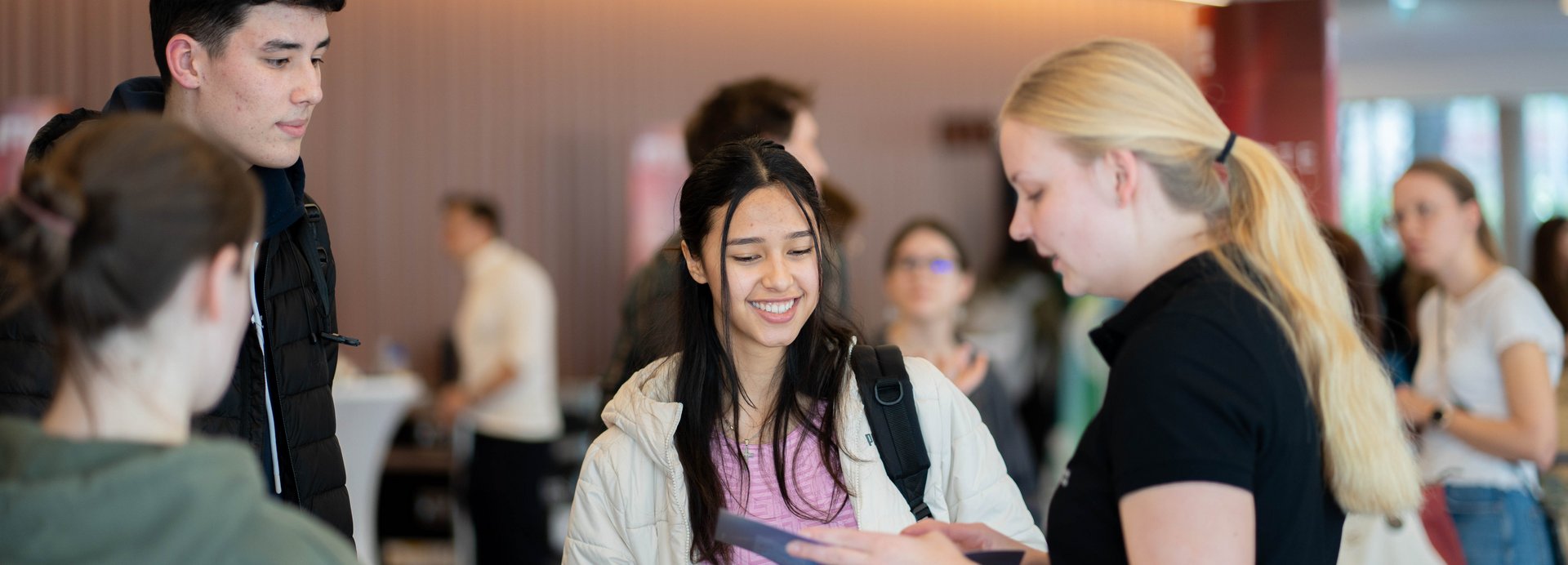 Eine Schülerin und ein Schüler werden von einer Studentin der Montanuniversität Leoben beraten.