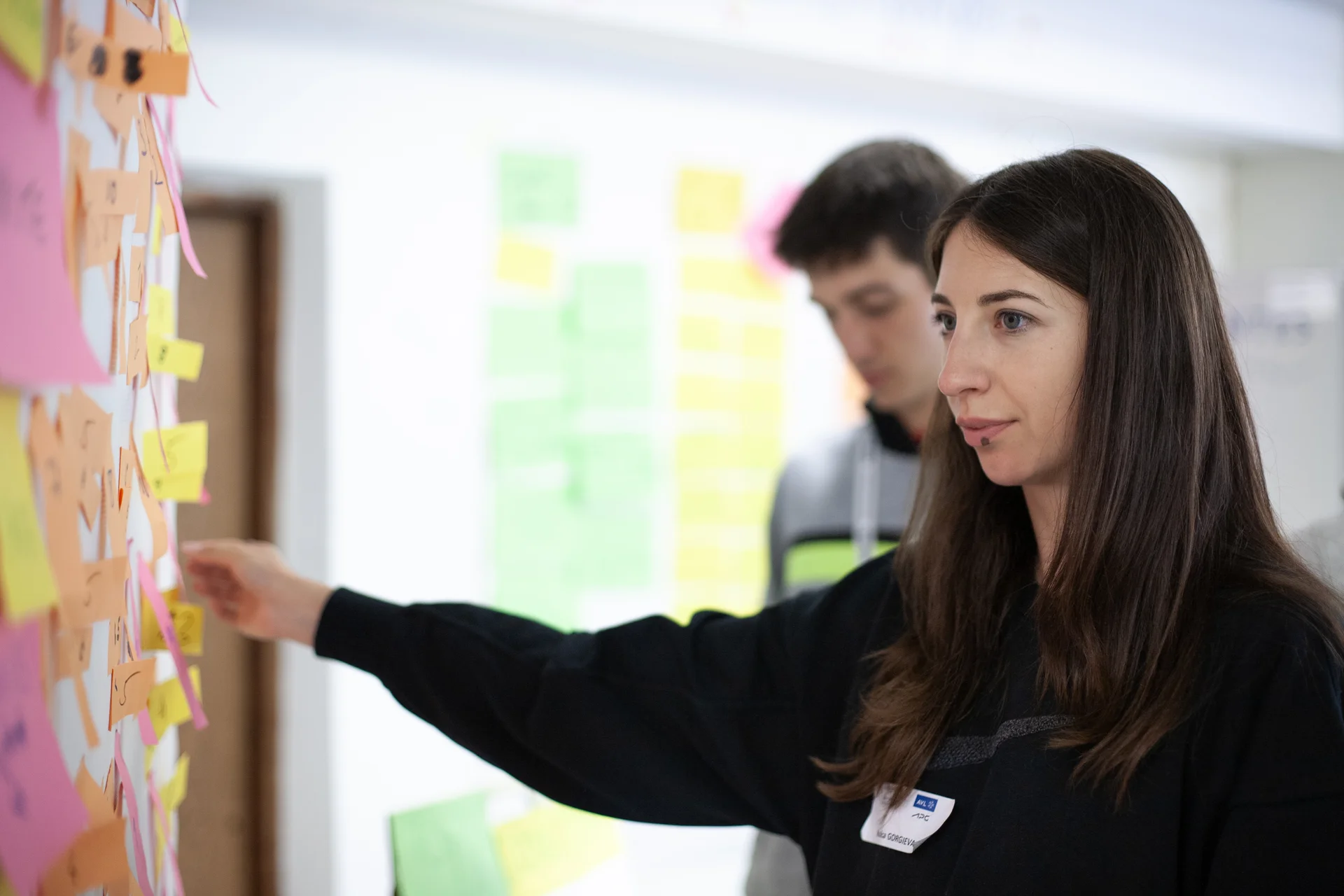 Studierenden-Teams arbeiteten an Lösungen Studentin steht an Flipchart.