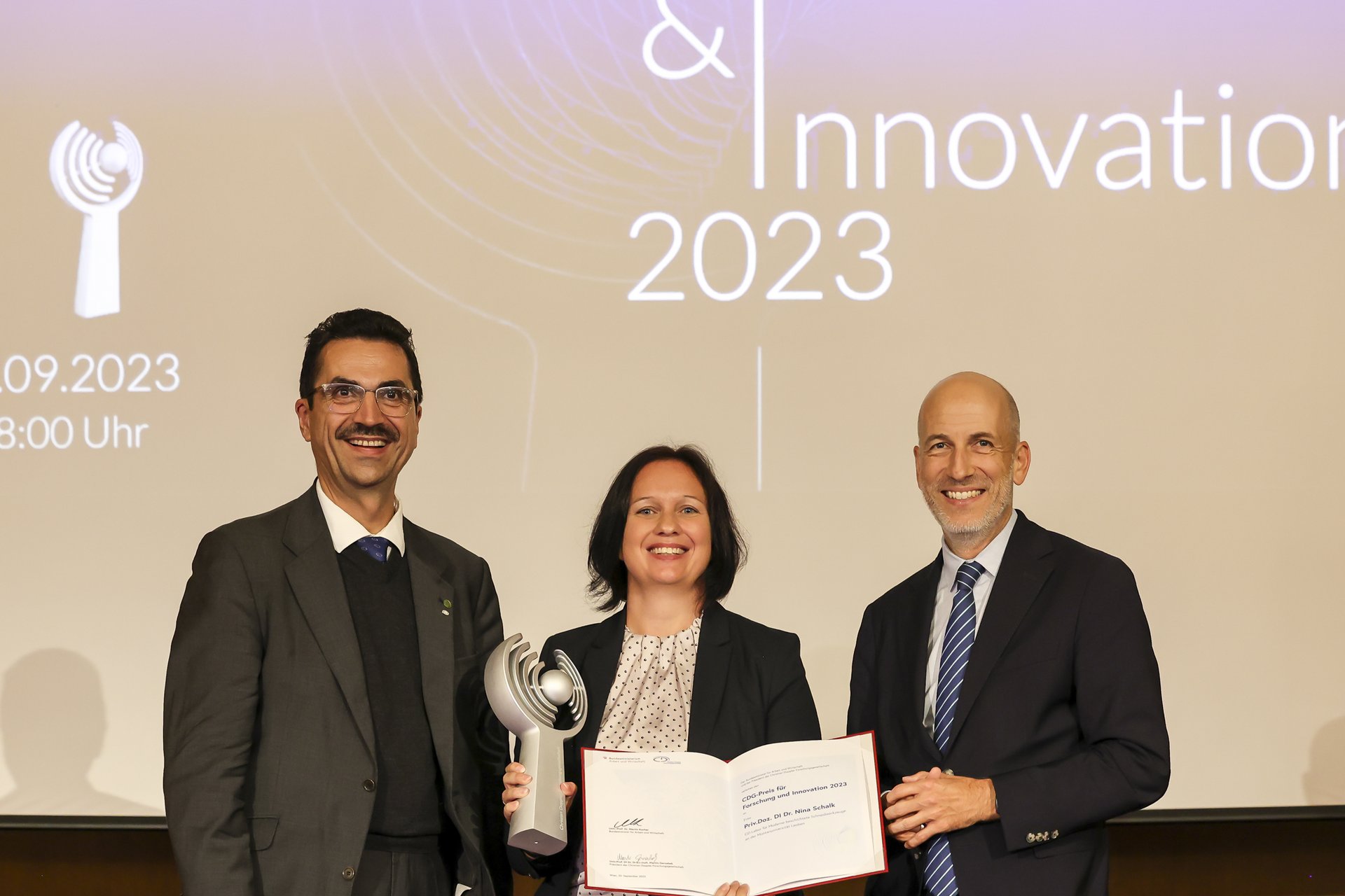 Martin Gerzabek, President of the CDG, Nina Schalk, Award winnerin and minister Martin Kocher at the Award. 