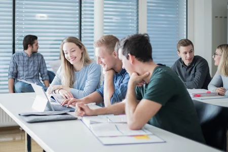 Studierende sitzen im Hörsaal vor dem Laptop.