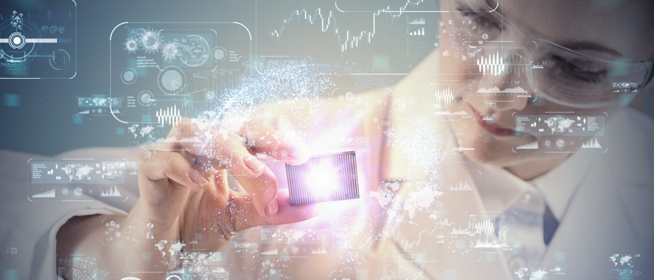 Researcher with chip in front of a digital graphic.