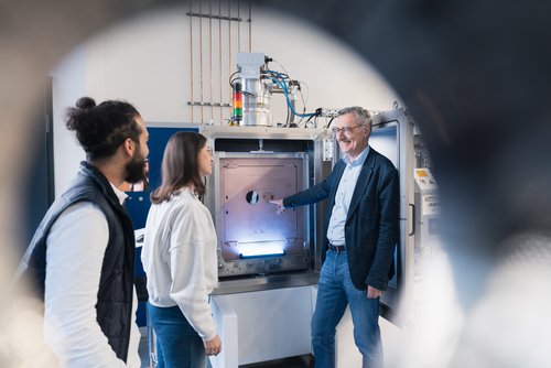 © MUL Professor erklärt zwei Studierenden ein Laborgerät.