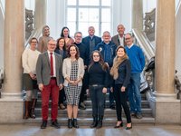 Gruppenbild der Verantwortlichen für die Kulturkoordination zwischen Montanuniversität und der Stadt Leoben auf einer Treppe im Universitätsgebäude.