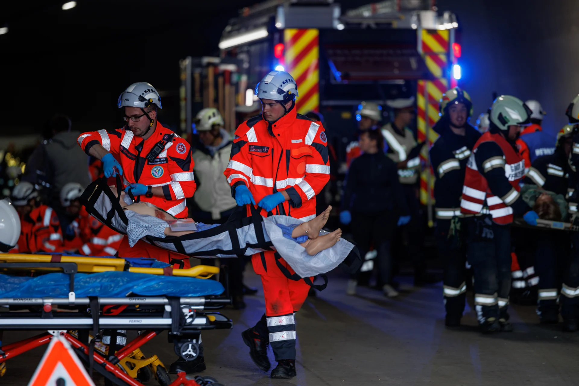 Übung zu Rettungseinsatz unter Tage. Übungsszenario im Tunnel mit Sanitätern und Verletzten auf einer Trage.