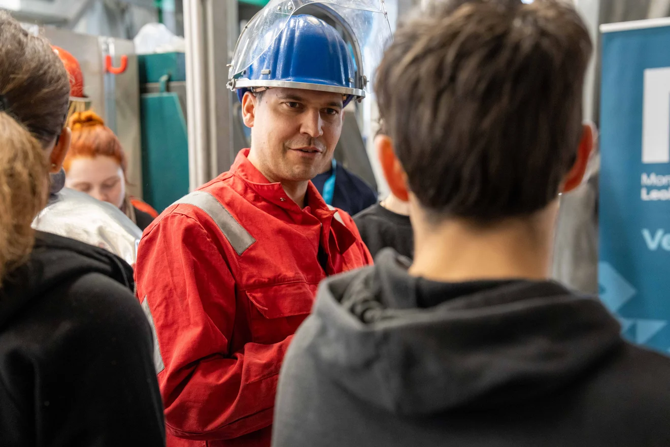 Professor mit Helm und Schülern auf der Montanuniversität, TU Leoben.