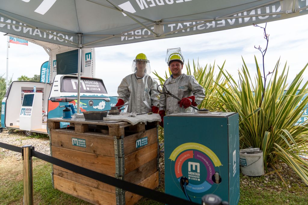 Zwei Mitarbeiter der Montanuniversität in Schutzanzügen beim Recyceln von Aluminiumdosen.