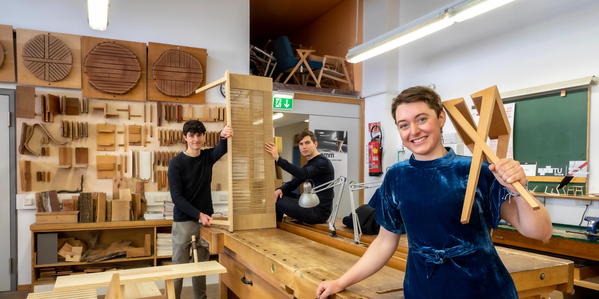 © Lunghammer – TU Graz Drei Studierende mit Möbeln in der TU Graz-Holzwerkstatt