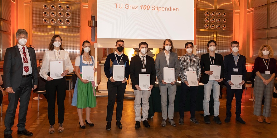 © Lunghammer – TU Graz Gruppe von jungen Menschen mit Urkunden, flankiert von zwei Repräsentanten der TU Graz