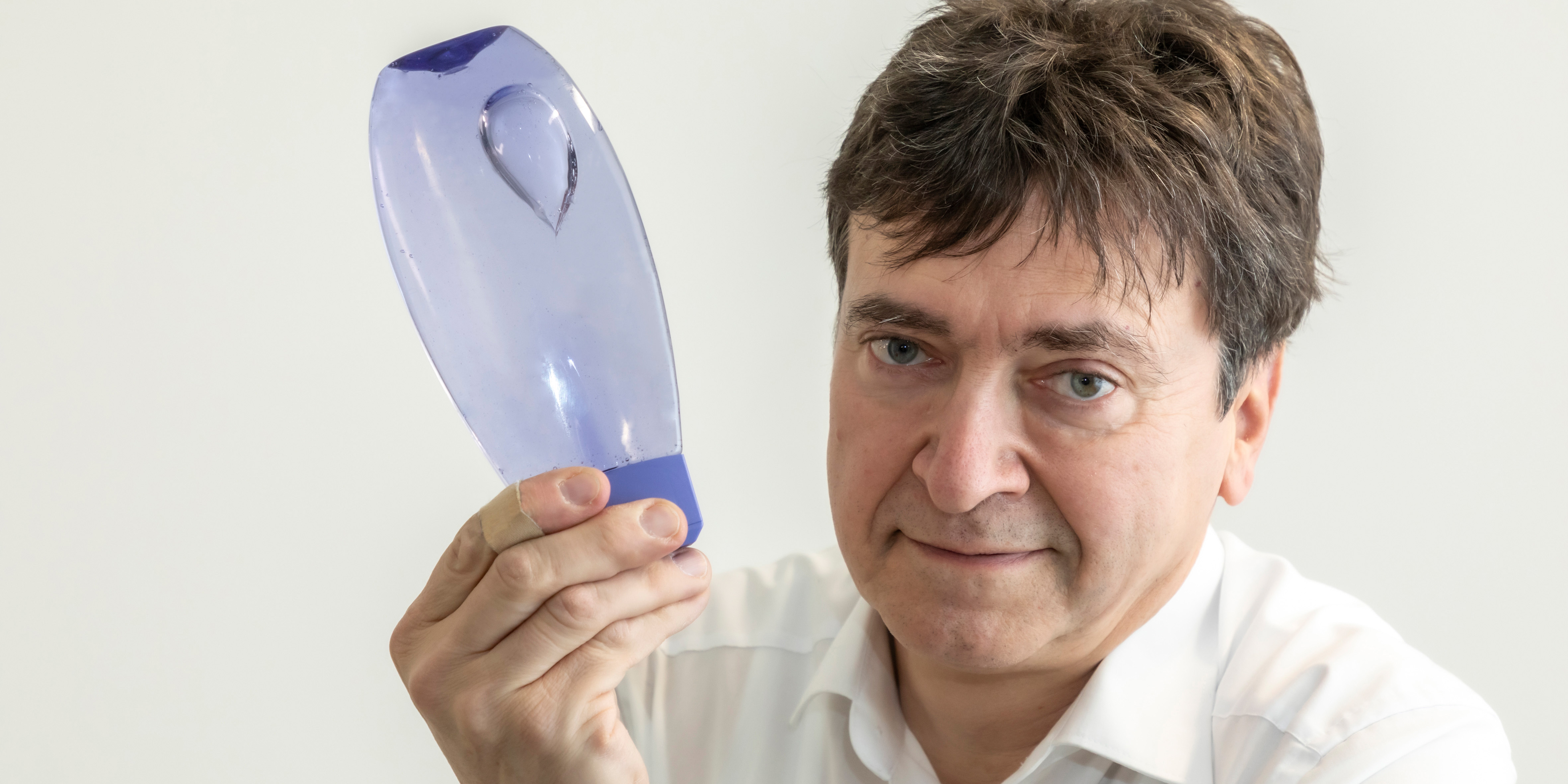 © Lunghammer – TU Graz Mann hält Flasche in Händen, in der Gasblasen aufsteigen